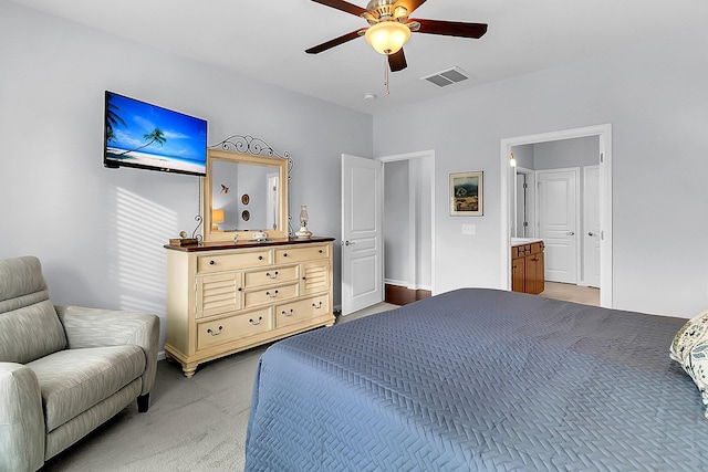 carpeted bedroom featuring ceiling fan and ensuite bath