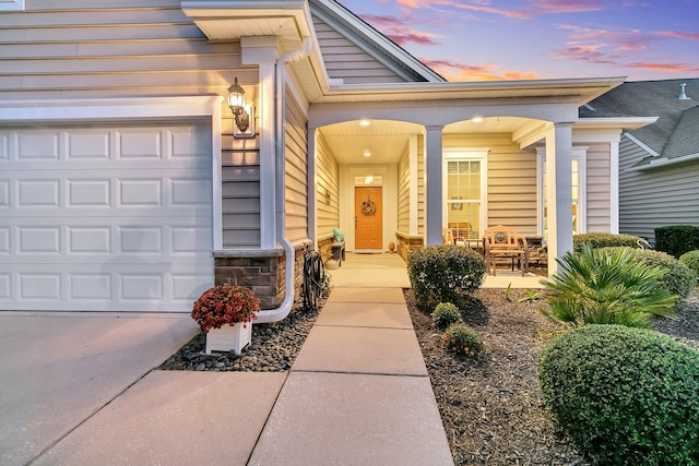 exterior entry at dusk with a garage and a porch