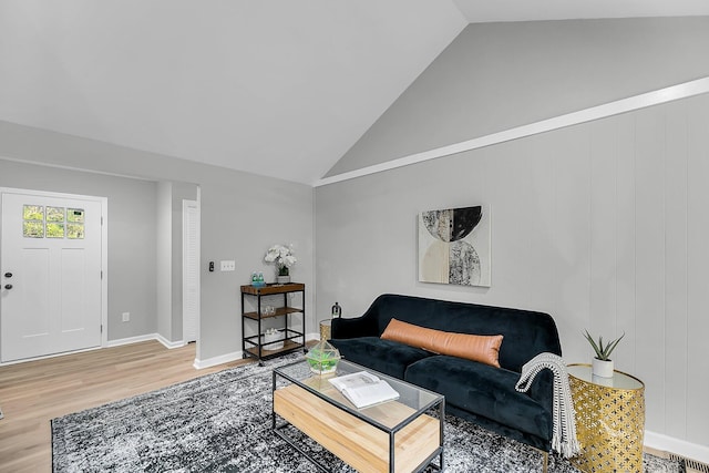 living area with baseboards, high vaulted ceiling, and wood finished floors