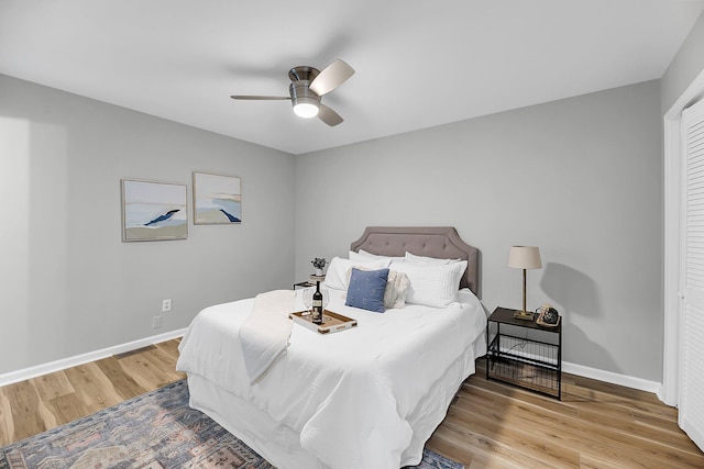 bedroom featuring a ceiling fan, baseboards, and wood finished floors