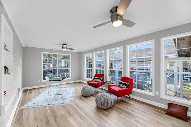 sunroom / solarium featuring visible vents, a healthy amount of sunlight, and a ceiling fan