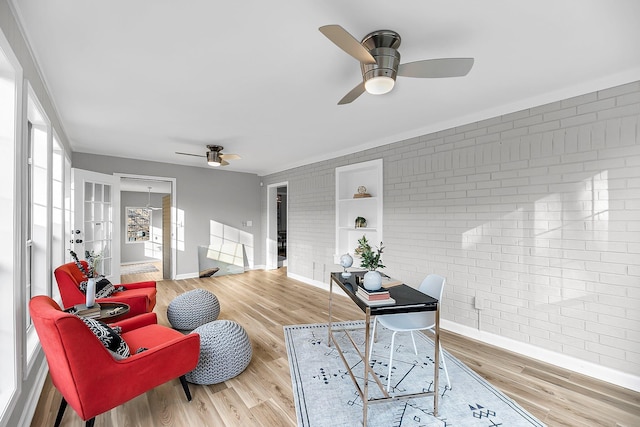 office featuring brick wall, baseboards, a ceiling fan, and wood finished floors