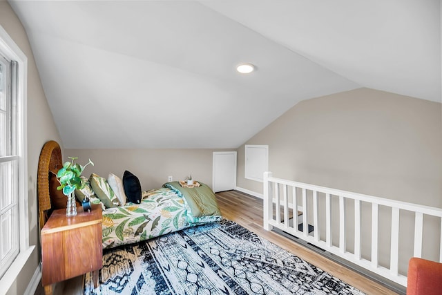 bedroom with vaulted ceiling and wood finished floors