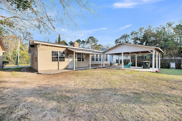 back of property featuring fence, a chimney, a yard, crawl space, and a patio