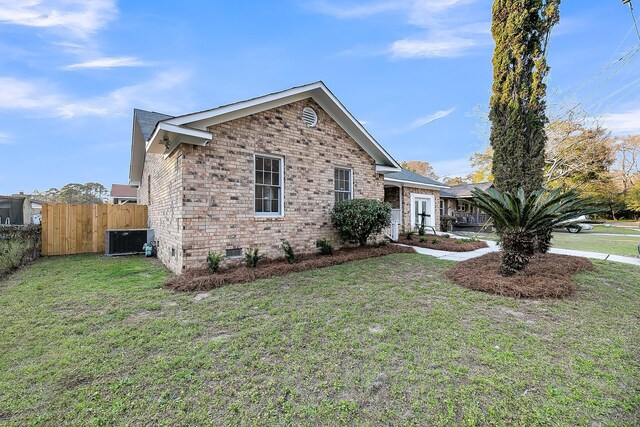 view of front of house with cooling unit, fence, a front lawn, crawl space, and brick siding