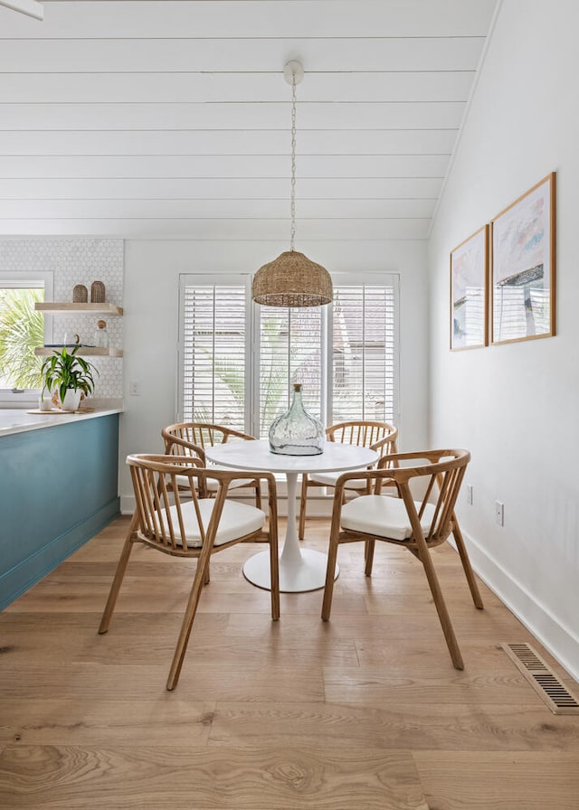 dining room with lofted ceiling and light hardwood / wood-style flooring