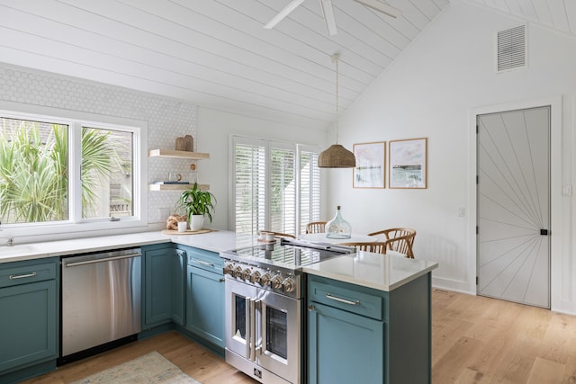 kitchen featuring light hardwood / wood-style floors, hanging light fixtures, stainless steel appliances, and kitchen peninsula