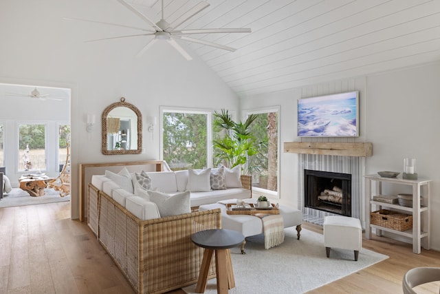 living room with a healthy amount of sunlight, light hardwood / wood-style flooring, and wooden ceiling