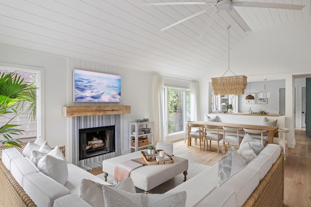 living room featuring wood ceiling, ceiling fan, light hardwood / wood-style floors, and vaulted ceiling