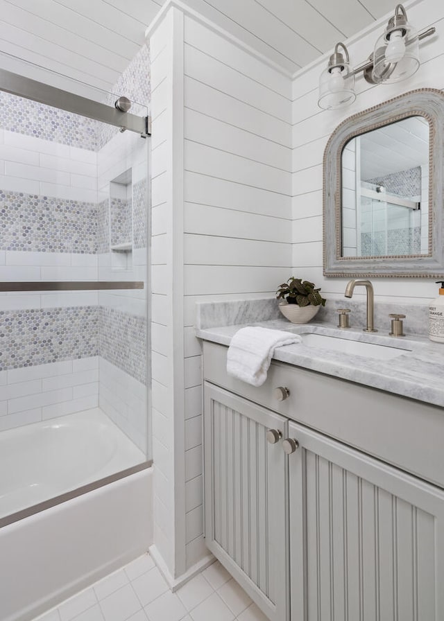 bathroom with vanity, combined bath / shower with glass door, tile patterned floors, and wooden walls