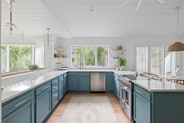 kitchen with blue cabinets, light hardwood / wood-style flooring, hanging light fixtures, stainless steel appliances, and backsplash