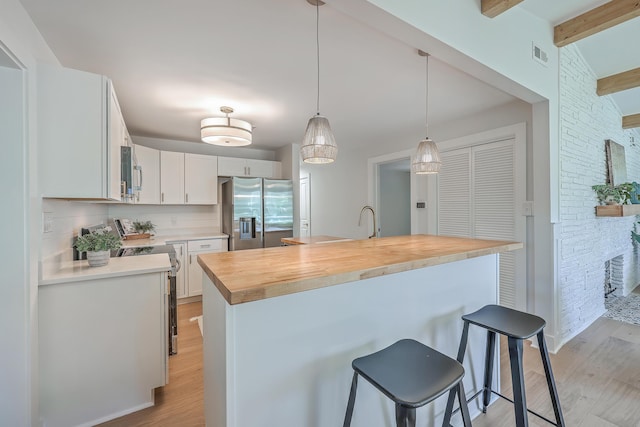 32 Briarcliff Dr, Charleston, SC 29407 - kitchen featuring appliances with stainless steel finishes, wood counters, light wood-style floors, a kitchen bar, and beamed ceiling