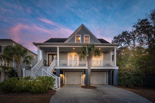 raised beach house with french doors, a garage, and covered porch