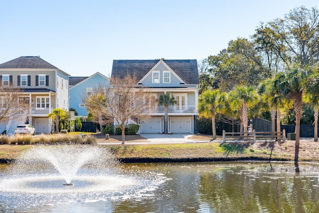 rear view of property with a garage and a water view