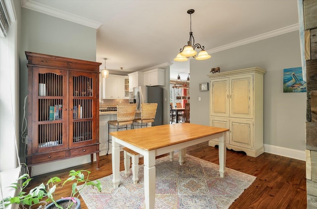 dining room with dark wood-type flooring, crown molding, and a notable chandelier