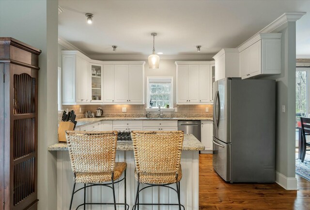 kitchen with decorative light fixtures, dark wood-type flooring, white cabinetry, and appliances with stainless steel finishes