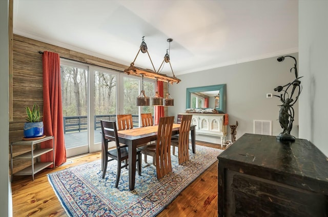 dining room featuring hardwood / wood-style floors and crown molding