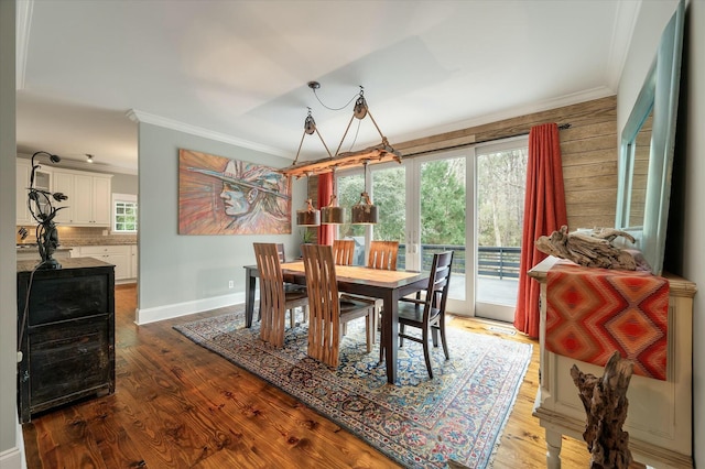 dining space with hardwood / wood-style floors and ornamental molding