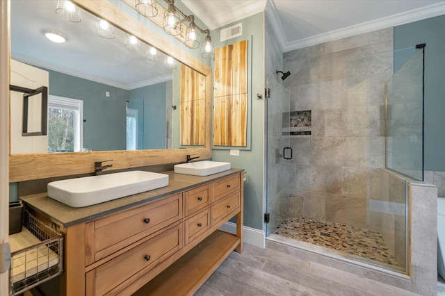 bathroom with a shower with door, vanity, and ornamental molding