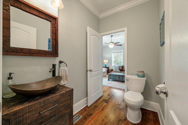 bathroom with vanity, ceiling fan, toilet, hardwood / wood-style flooring, and crown molding