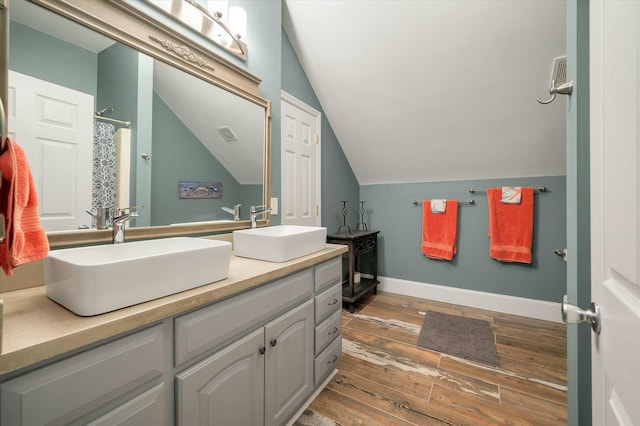 bathroom with lofted ceiling, vanity, and curtained shower