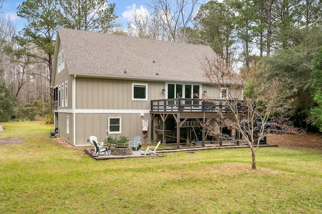 rear view of property featuring a wooden deck, a yard, a patio, and a fire pit