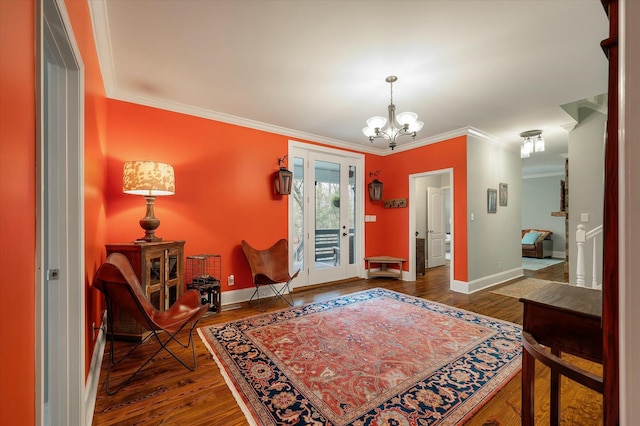 foyer entrance with dark hardwood / wood-style floors, ornamental molding, and an inviting chandelier