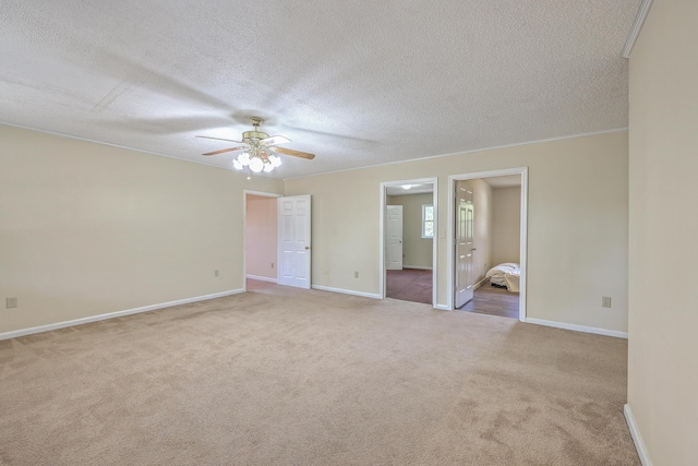 unfurnished bedroom with crown molding, baseboards, carpet floors, and a textured ceiling