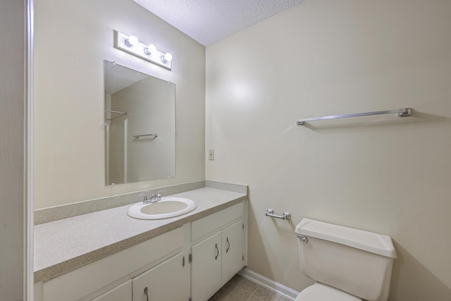 bathroom featuring vanity, toilet, and a textured ceiling