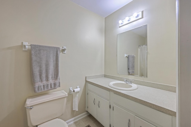 bathroom featuring vanity, toilet, and baseboards