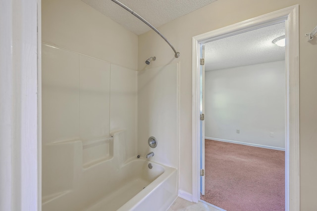 bathroom with a textured ceiling, baseboards, and washtub / shower combination