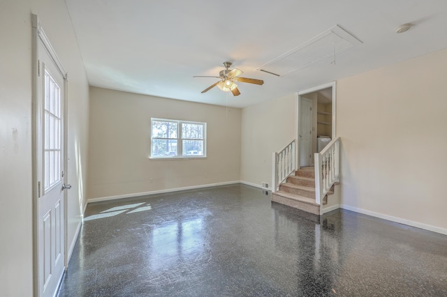 empty room with baseboards, attic access, and stairs