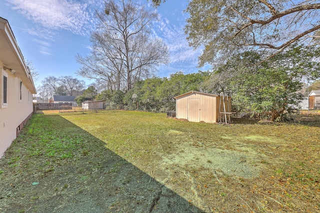 view of yard with a storage unit, an outbuilding, and fence