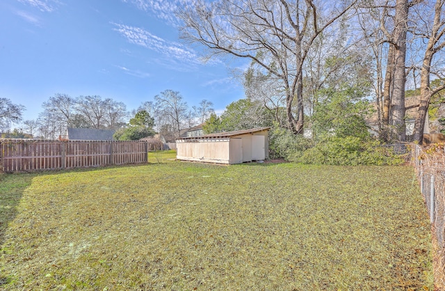 view of yard featuring an outbuilding, a storage unit, and fence