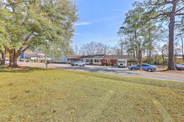 ranch-style house featuring a front lawn and driveway