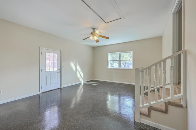 empty room featuring stairway, a healthy amount of sunlight, and baseboards