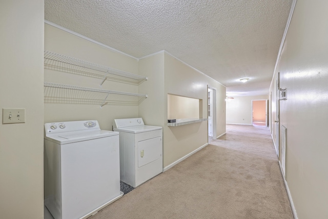 laundry room with laundry area, light colored carpet, a textured ceiling, and ornamental molding