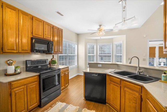 kitchen featuring black appliances, ceiling fan, light hardwood / wood-style flooring, and sink