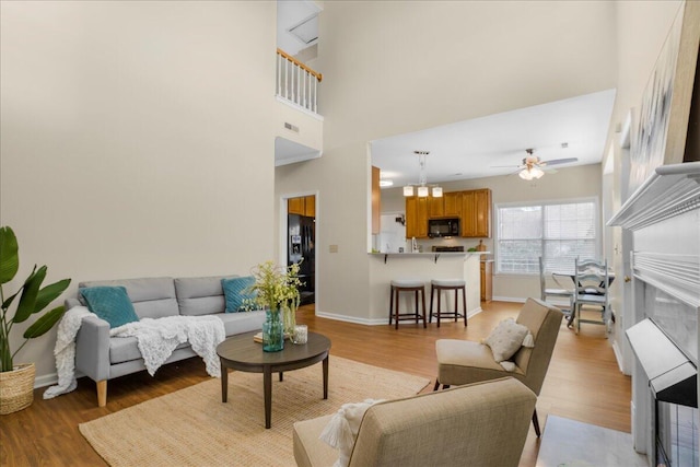 living room with light hardwood / wood-style flooring and ceiling fan