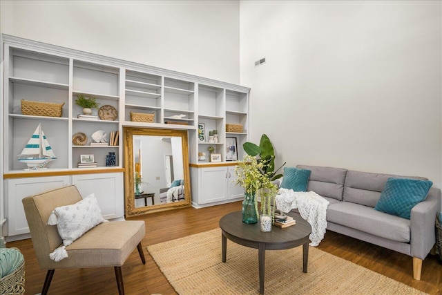 living area with hardwood / wood-style floors and a high ceiling