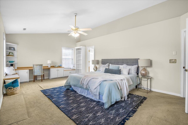 carpeted bedroom featuring ceiling fan, lofted ceiling, and built in desk