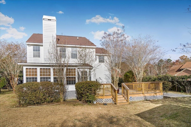 rear view of house with a wooden deck and a yard