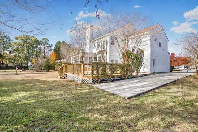 rear view of property featuring a wooden deck and a yard