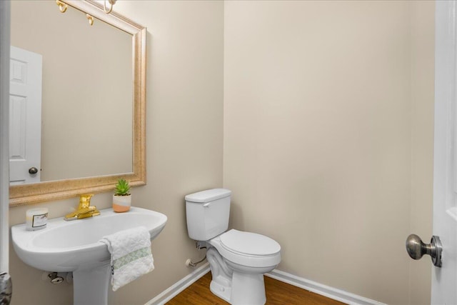 bathroom with sink, hardwood / wood-style floors, and toilet