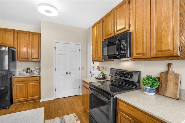 kitchen featuring black appliances and dark hardwood / wood-style flooring