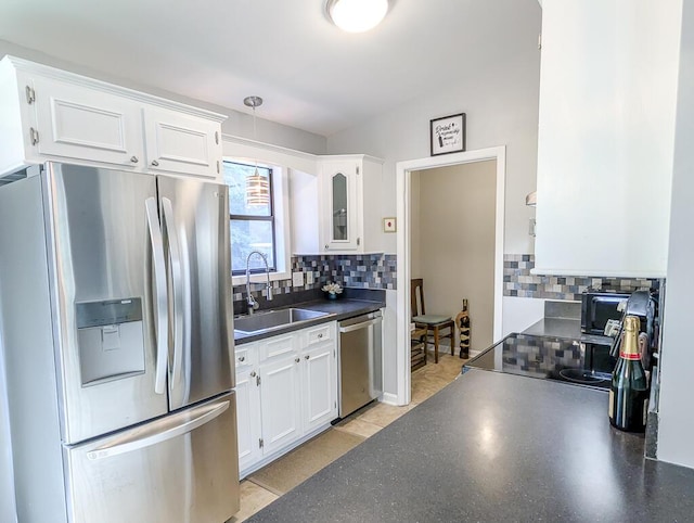 5 Drummond Ct, Charleston, SC 29414 - kitchen with stainless steel appliances, a sink, dark countertops, white cabinets, and decorative backsplash