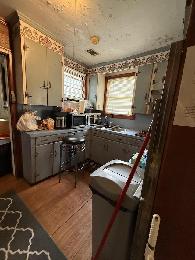 715 Yew St, Charleston, SC 29407 - kitchen featuring light wood-style floors, stainless steel microwave, and a sink