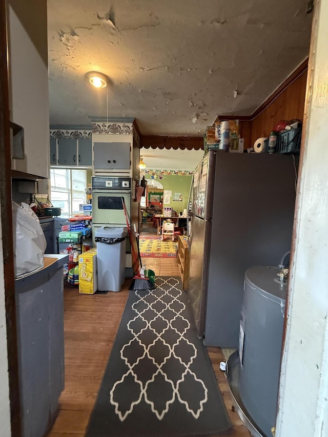 715 Yew St, Charleston, SC 29407 - kitchen featuring white oven, freestanding refrigerator, wood finished floors, and water heater