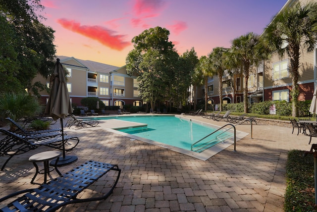 pool at dusk with a patio