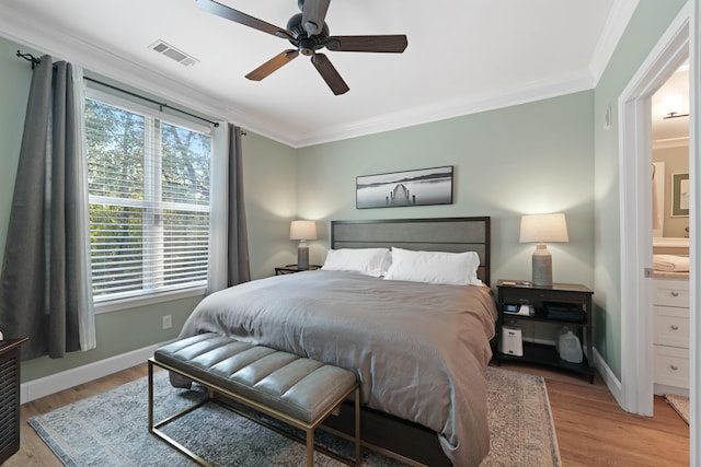 bedroom featuring ceiling fan, light wood-type flooring, ensuite bath, and crown molding